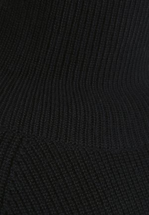 Gros plan sur un tissu en maille côtelée noire montrant des motifs de points verticaux et horizontaux détaillés avec de subtiles variations de texture.