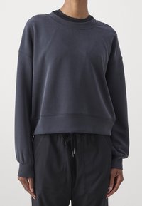 Sudadera de algodón gris oscuro con cuello redondo, hombros caídos y un diseño corto. Presenta puños acanalados y una textura suave.