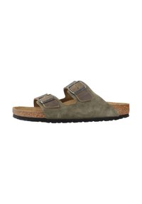 Sandalo slide in suede verde oliva con due cinturini regolabili e fibbie metalliche, soletta in sughero e suola in gomma nera.