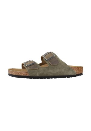 Mules en daim vert olive avec deux brides réglables dotées de boucles métalliques, semelle en liège et semelle extérieure en caoutchouc noir.