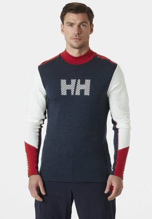 Langarmtrui in marineblauw, wit en rood. Beschikt over een geribbelde kraag, gestreept "HH"-logo en kleurblockmouwen met contrasterende accenten.