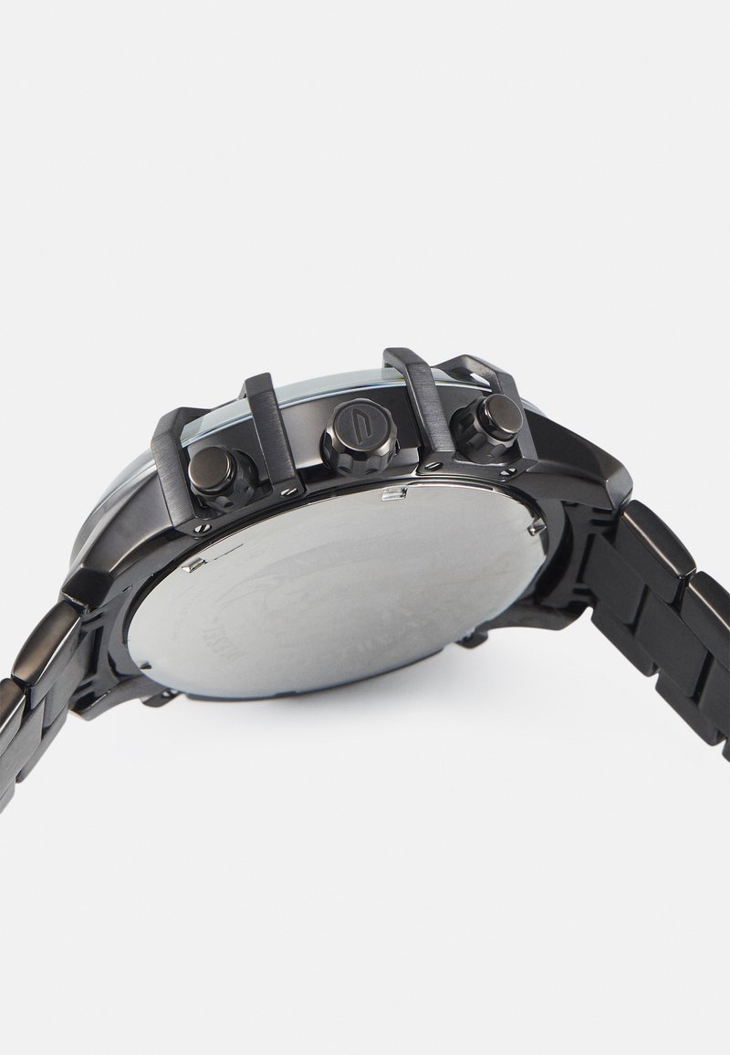 Schwarze Metallarmbanduhr mit dickem Design, ausgestattet mit drei Druckknöpfen, einer glatten Lünette und einem Metallarmband. Die strukturierte Rückseite ist silberfarben.