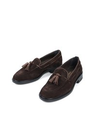 Brązowe zamszowe loafersy z chwostami, szyte w stylu mokasynów, z elegancką czarną podeszwą. Posiadają dekoracyjne boczne akcenty.