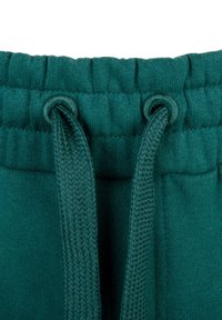 Grüne Sweatpants mit einem strukturierten Bündchen, ausgestattet mit zwei Metallösen und einem gewobenen Kordelzug zur Anpassung. Aus weichem Fleece-Material.