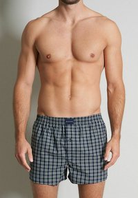 Blaue und weiße karierte Boxershorts mit elastischem Bund und Frontknopf. Aus Baumwollmaterial, entspannte Passform und Karomuster.