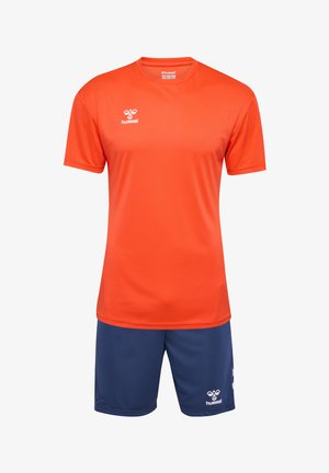Maglietta sportiva arancione con maniche corte e collo rotondo, abbinata a pantaloni corti blu navy. Entrambi gli articoli presentano il logo Hummel in bianco.