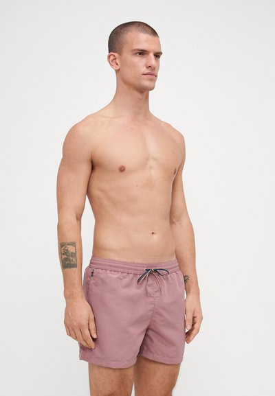 Shorts de bain roses courts avec une taille élastique, cordon de serrage et poche latérale. Design simple avec une texture lisse et sans motifs visibles.
