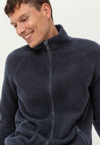 Marineblaue Fleecejacke mit hohem Kragen, durchgehendem Reißverschluss und Seitentaschen. Die weiche Textur und die Raglanärmel verleihen ihr zusätzliches Design.