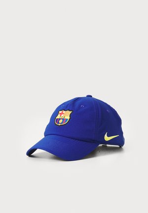 Blå bomulds kasket med et broderet Barcelona-logo i rød, gul og blå; Nikes gule swoosh accent på siden.