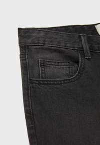 Jeans in denim nero con vita standard, tasca anteriore e cuciture pulite. Il tessuto appare liscio con una leggera lucentezza.