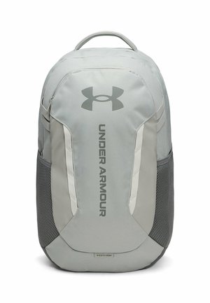 Lichtgrijze Under Armour rugzak met bovenhandvat, mesh zijvakken en verticale logotekst op het voorpaneel.