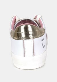 Sneaker bianco con tallone metallico argento, fodera interna rosa e accento rosa sull'esterno. Texture liscia con dettagli di cucitura a contrasto.
