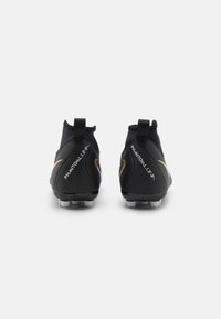 Scarpe da calcio nere con un design elegante, caratterizzate da una tomaia testurizzata, accenti dorati e un logo bianco. Design alla caviglia corto e basso.