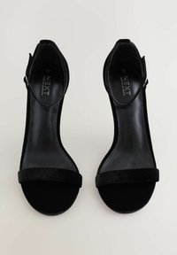 Sorte højhælede sandaler med et elegant design, der har en struktureret velourrem og en glat, blank sål. Justerbar ankelrem inkluderet.