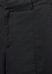 Black linen trousers with a smooth texture, featuring front pockets and contrasting stitching on the seams.