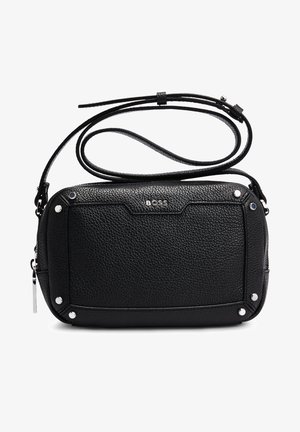 Bolso bandolera de cuero negro texturizado con tachuelas plateadas, cierre de cremallera, correa ajustable y logotipo "BOSS" centrado en el panel frontal.