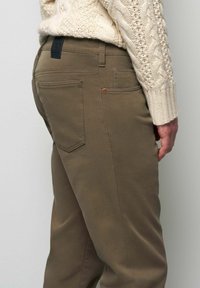Khaki broek gemaakt van een duurzame katoenmix, met een slim fit, subtiele textuur, achterzakken en een zwarte merklabel op de tailleband.
