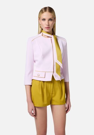 Pink structured jacket with yellow accents and buttons, paired with yellow shorts. Features a matching scarf tied around the neck.