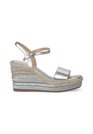 Wedge sandals with a silver metallic finish, wide front strap, ankle strap with buckle, and textured jute-wrapped heel with decorative accents.