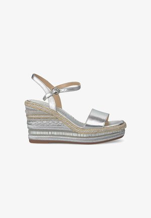 Sandales compensées avec une finition métallique argentée, large bride avant, bride de cheville avec boucle et talon en jute texturé enveloppé avec des accents décoratifs.