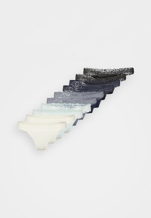 Stapeltje van zeven met kant afgewerkte vrouwen onderbroeken in een verloop van kleuren van crème tot zwart, diagonaal gerangschikt op een witte achtergrond.