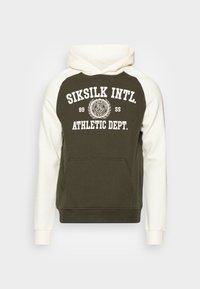 Sudadera con capucha que presenta un cuerpo de color verde oliva con mangas blancas, bolsillo delantero y un texto gráfico grande que dice "SIKSILK INTL. ATHLETIC DEPT."