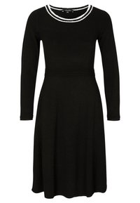 Robe noire à manches longues avec une taille cintrée et une jupe évasée. Présente un col rayé blanc et des détails en côtes au niveau des poignets.