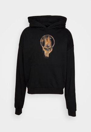 Sudadera negra con un corte relajado. Presenta un gráfico circular de la cara de un león en tonos cálidos. Incluye un bolsillo frontal y puños acanalados.