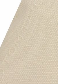 Beige textured fabric swatch with subtle raised hexagonal pattern and faint embossed text partially visible across the surface.