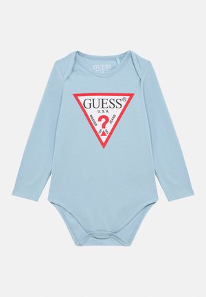 Pelele para bebé de manga larga en azul claro con cierres de presión, que presenta un logo triangular de Guess en rojo y blanco con texto y un signo de interrogación.