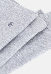 Tessuto di cotone grigio impilato in tre strati, con una trama fine e un piccolo logo ricamato sul pezzo superiore.