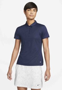 Námornická polokošeľa s golierom a trojradovým zapínaním, spojená s bielou sukňou s čiernymi bodkami a logom na leme.