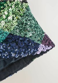 Tessuto ricoperto di paillettes nei toni verde, blu e viola, caratterizzato da una superficie testurizzata e scintillante con paillettes circolari disposte in un design a mosaico.