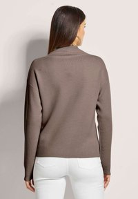 Brauner gestrickter Pullover mit hohem Kragen, überschnittenen Schultern und langen Ärmeln, mit gerippten Bündchen und einem lockeren Schnitt am Saum.