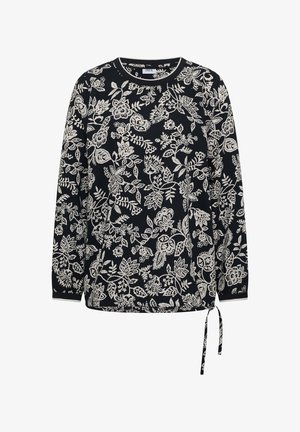 Haut noir à manches longues avec motif floral et feuilles blanches, encolure ronde, et lien latéral ajustable à l'ourlet.