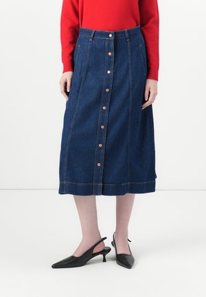 Denim midi skjørt med rett snitt, kopperknapper og subtile sømmer. Kombinert med svarte slingback hæler for kontrast.