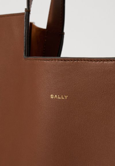 Barna bőr tote táska arany "BALLY" logóval. Simább textúrával és letisztult vonalakkal rendelkezik, kiemelve a minimalista dizájnt.