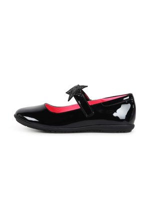 Chaussure Mary Jane noire brillante avec une décoration en forme d'étoile sur la bride et un intérieur rouge vif, vue de profil sur fond blanc.