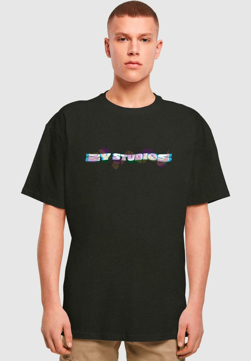 Černé bavlněné tričko s krátkým rukávem, na kterém je lesklé, vícebarevné logo "EZ STUDIOS" napříč hrudí.