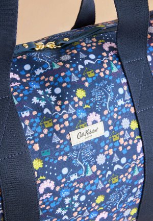Námornícka taška vyrobená z vzorovanej tkaniny s kvetinovými a domovými vzormi, so zipsom a zlatými kovovými detailami, označená štítkom "Cath Kidston".