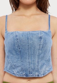 Top scurt din denim cu decolteu pătrățos, bretele subțiri și un design ajustat. Nuanta albastru deschis cu detalii de cusătură vizibile și textură netedă.