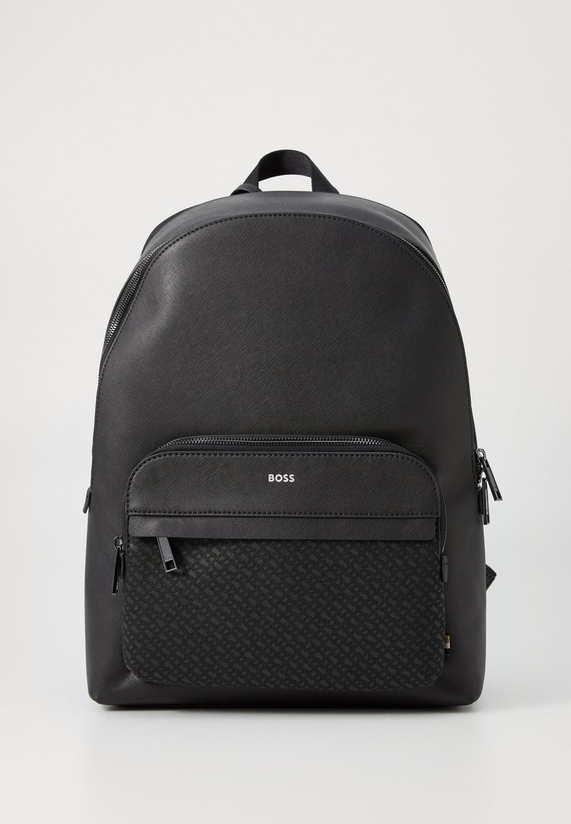 Black backpack with a smooth finish and textured front pocket. Features a logo, zippers, and a curved top. Durable material for daily use.