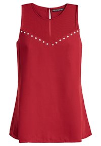 Blusa rossa senza maniche con un orlo leggermente svasato, caratterizzata da una schiena a chiave e dettagli a borchie metalliche lungo il collo. Tessuto liscio.