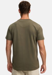 Olivegrünes Baumwoll-T-Shirt mit kurzen Ärmeln, rundem Ausschnitt und Rückenpasse. Es hat eine glatte Textur und einen lockeren Schnitt.