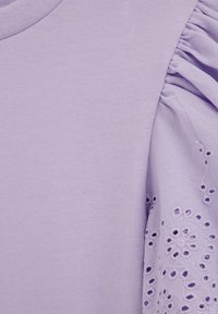 Fialové bavlnené tričko s hladkým telom a volánovým rukávom s prepracovanou kvetinovou výšivkou, ktorá pridáva textúru a detaily.