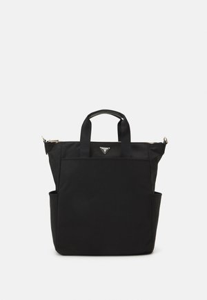 Sac fourre-tout noir avec deux poignées, poche avant, poches latérales et un logo Guess triangulaire sous la fermeture éclair sur fond blanc.