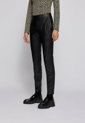 Zwarte nepleren broek met een slim fit, met een gladde textuur en een rits aan de zijkant. Gekocht met zwarte schoenen en een gebloemd top.