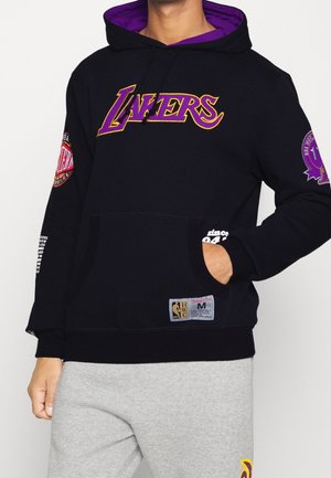 Felpa nera con fodera viola, caratterizzata da logo ricamato dei "Lakers", toppe sulle maniche, tasca a marsupio e etichetta hardware NBA sull'orlo.