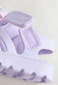 Sandali viola in plastica testurizzata, con cinturini in Velcro, design aperto e suola scanalata per una migliore aderenza.