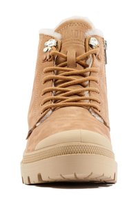 Bottines en cuir tan avec un intérieur en peluche, dotées d'œillets en métal, de lacets plats et d'une semelle en caoutchouc avec un motif texturé.